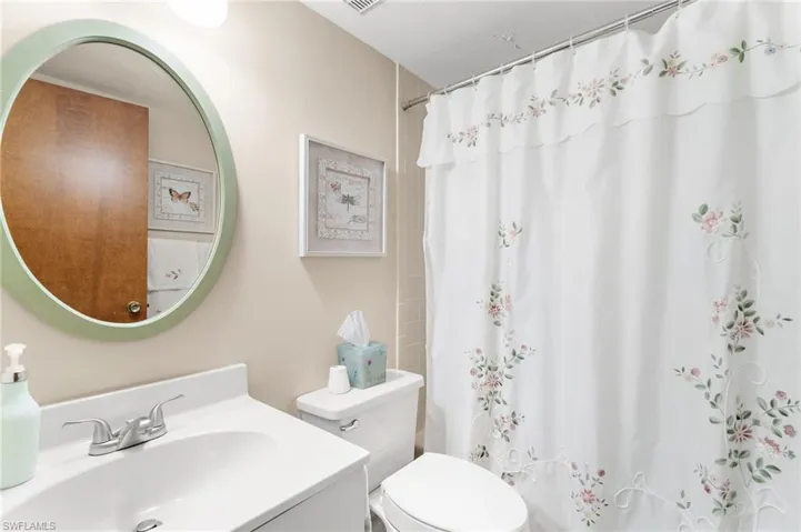 Bathroom with a shower with shower curtain and vanity