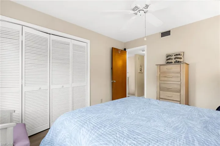 Bedroom with a ceiling fan, a closet, and dark wood-type flooring