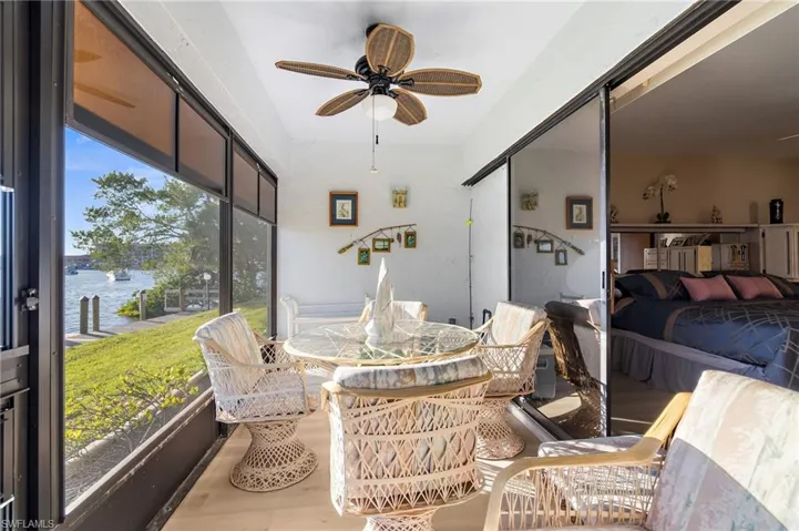 Sunroom / solarium with ceiling fan, a water view, and outdoor dining area