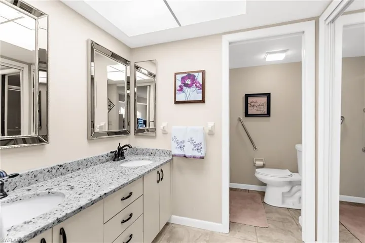 Full bath featuring double vanity and light tile patterned floors