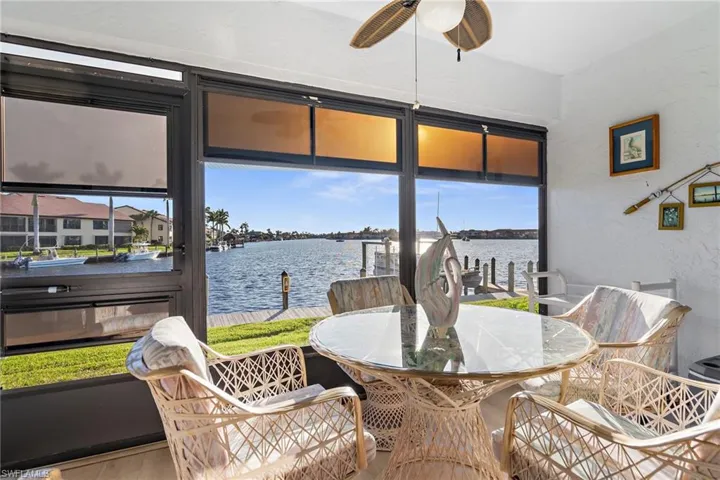 Sunroom with a textured wall, a water view, and wood finished floors