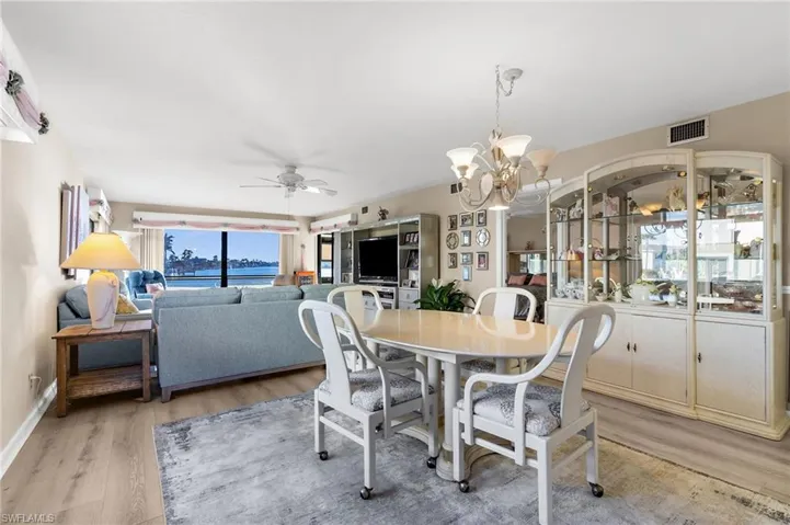 Dining space featuring a chandelier, a ceiling fan, and light wood-style floors