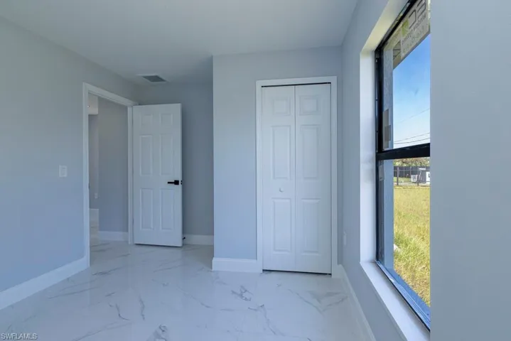 Unfurnished bedroom featuring a closet and multiple windows