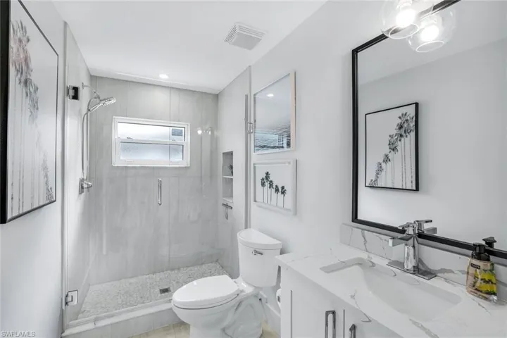 Bathroom with vanity, toilet, and an enclosed shower