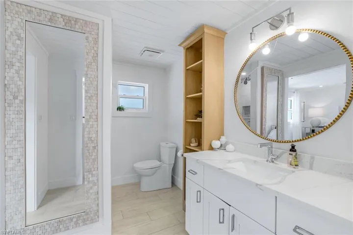Bathroom featuring wooden ceiling, vanity, and toilet