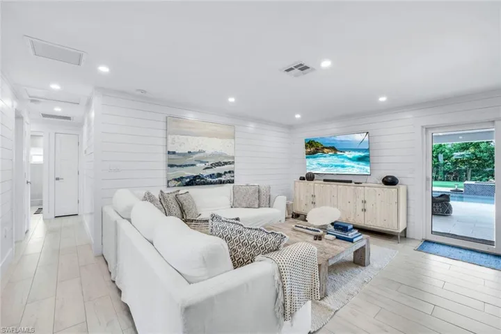 Living room featuring light wood-type flooring and wood walls