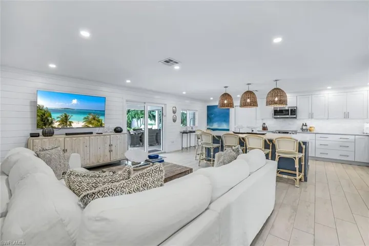 Living room with crown molding, light hardwood / wood-style floors, and wood walls