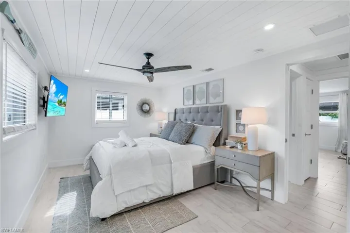 Bedroom with ceiling fan, light wood-type flooring, and wood ceiling