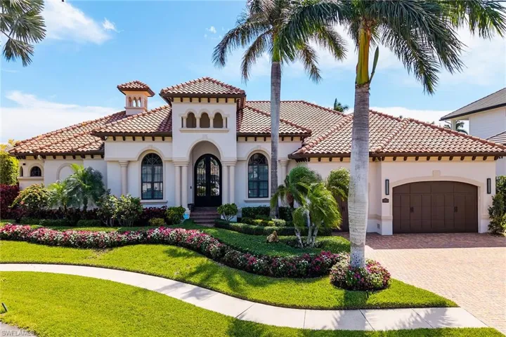Mediterranean / spanish home with french doors, stucco siding, decorative driveway, a front lawn, and an attached garage