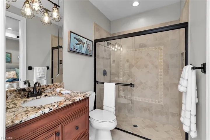 Full bathroom with vanity, connected bathroom, a shower stall, and recessed lighting