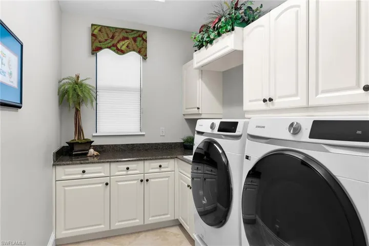 Laundry area with cabinet space and washing machine and clothes dryer