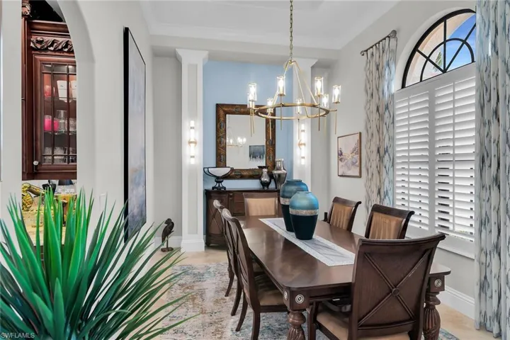Dining space featuring hanging lights and crown molding