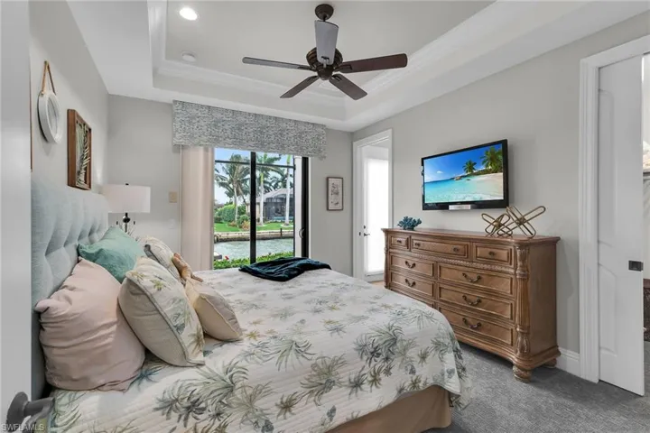 Bedroom with crown molding, dark carpet, ceiling fan, access to exterior, and ensuite bathroom