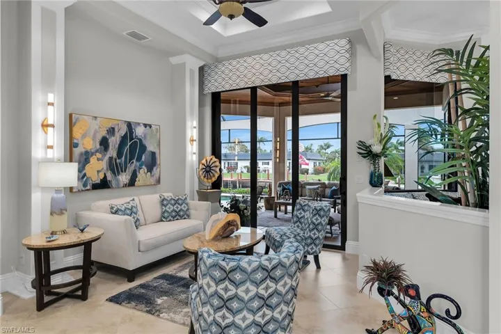 Tiled living room with ceiling fan and crown molding