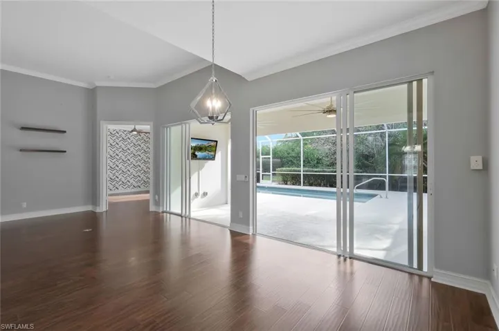 Spare room with ornamental molding, baseboards, ceiling fan, and wood finished floors