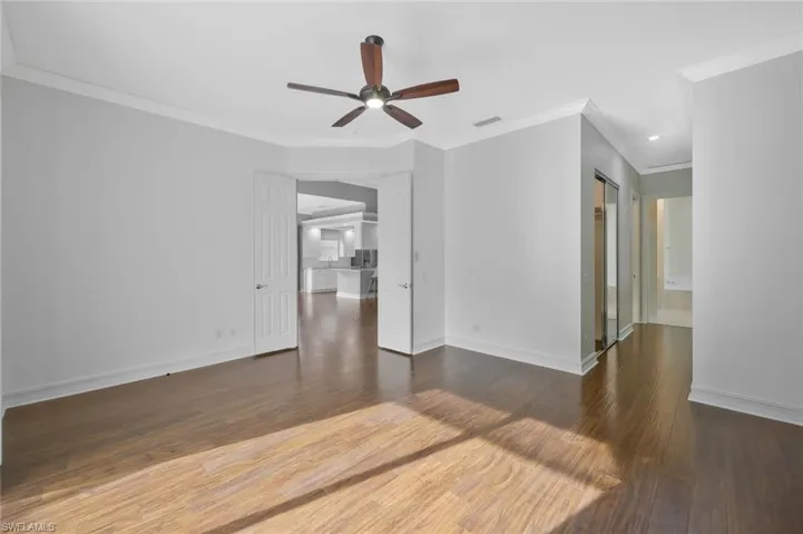Unfurnished room with baseboards, visible vents, wood finished floors, and a ceiling fan