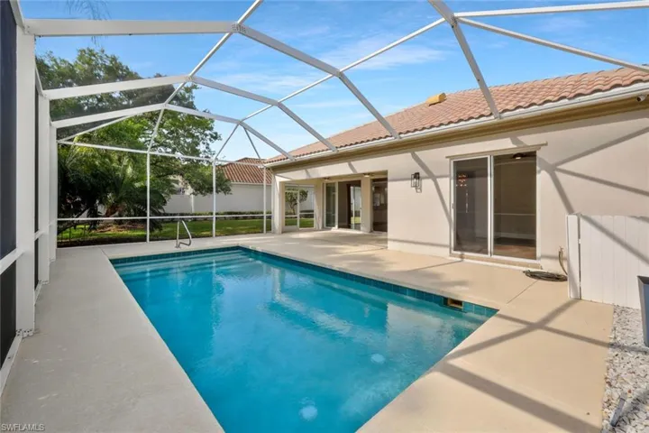View of swimming pool with a patio, a fenced in pool, and glass enclosure