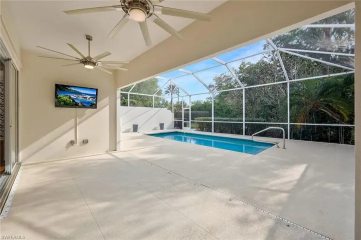 Pool with ceiling fan, a lanai, and a patio area