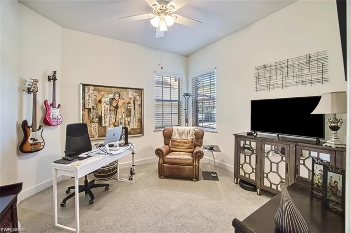 Office area featuring baseboards, carpet floors, and a ceiling fan