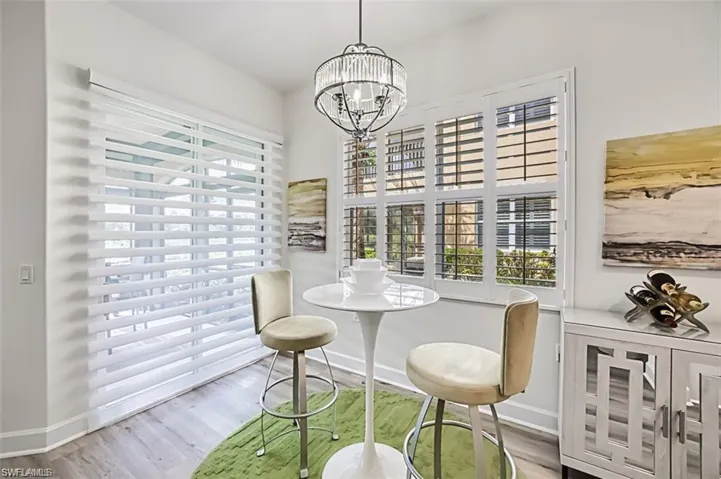 Dining room with baseboards, a chandelier, and wood finished floors