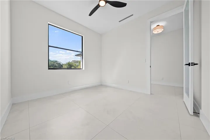 Unfurnished room with vaulted ceiling and a ceiling fan