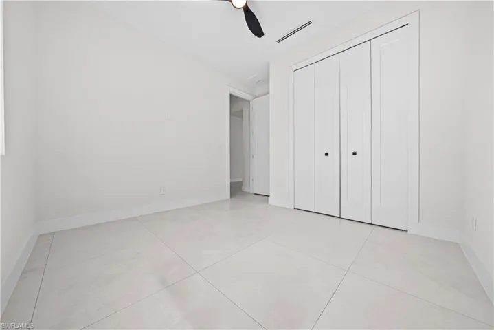 Unfurnished bedroom with a ceiling fan and a closet