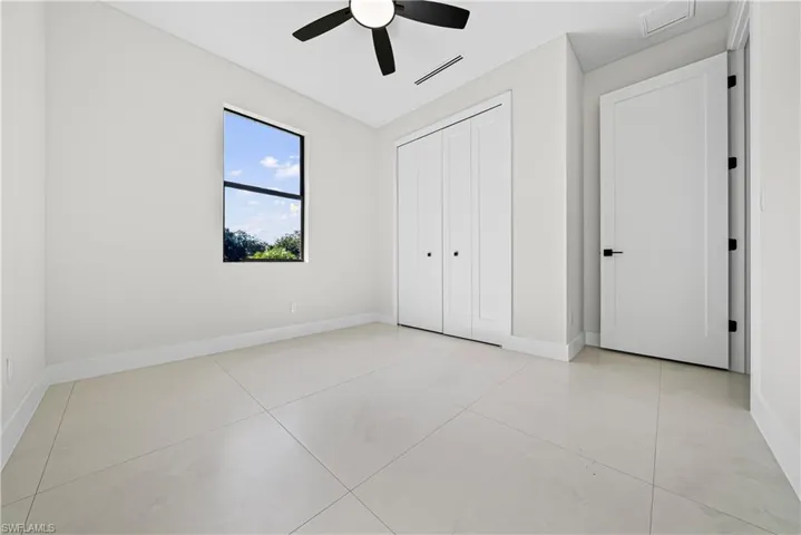 Unfurnished bedroom with a ceiling fan, a closet, and light tile patterned flooring
