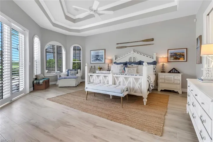 Generous primary bedroom with custom ceiling finishes and sitting area for morning coffee.