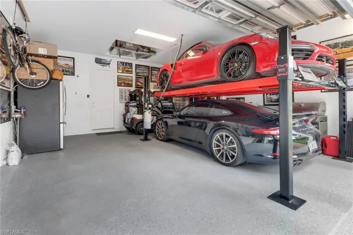 Spacious garage provides car lift that allows 3 cars to be parked.