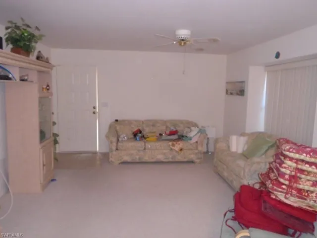 Living room featuring carpet flooring and ceiling fan