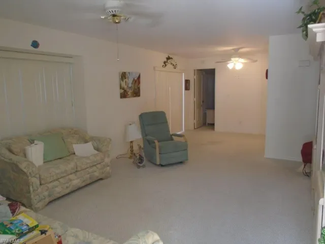 Living room featuring ceiling fan and carpet flooring
