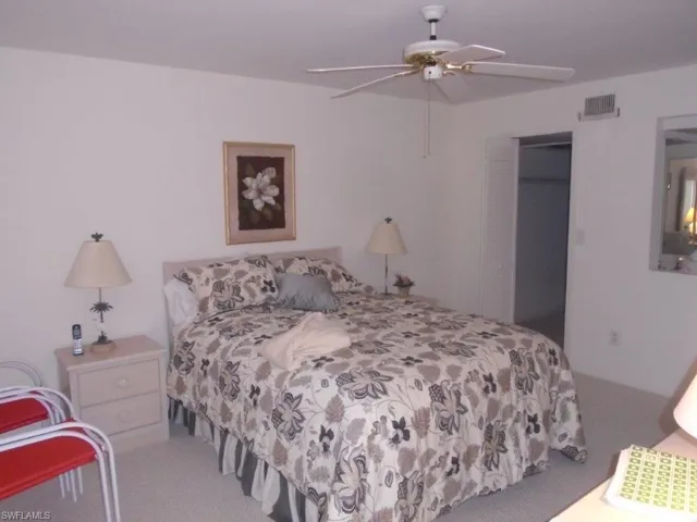 Carpeted bedroom featuring a closet and ceiling fan