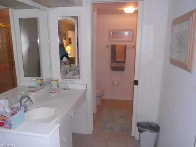 Bathroom with oversized vanity, toilet, and tile floors