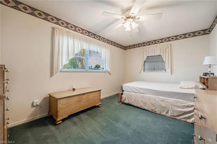 Bedroom with carpet floors, a ceiling fan, and baseboards