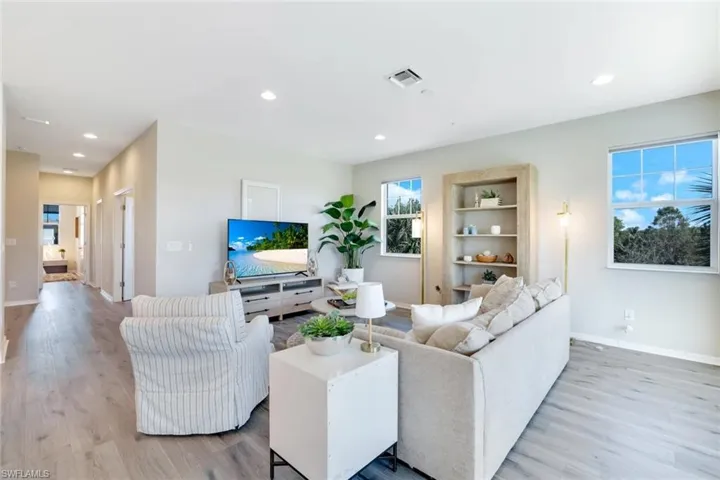 Living room with recessed lighting, light wood finished floors, and built in features