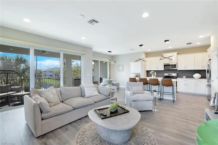 Living room with light wood finished floors and recessed lighting