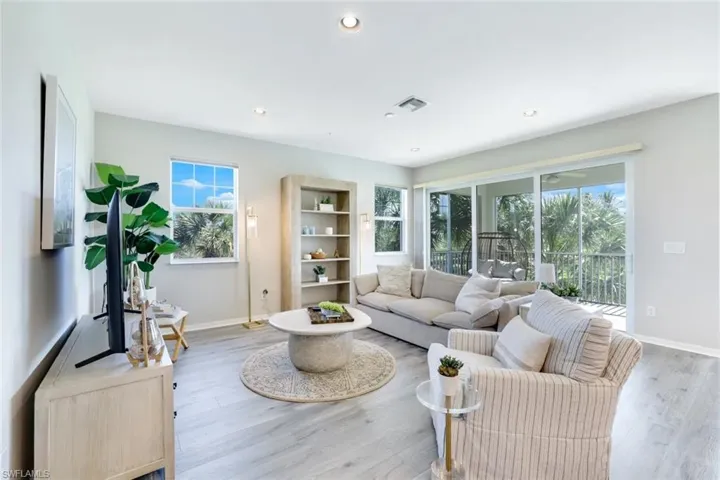 Living area with plenty of natural light, light wood-style floors, and recessed lighting