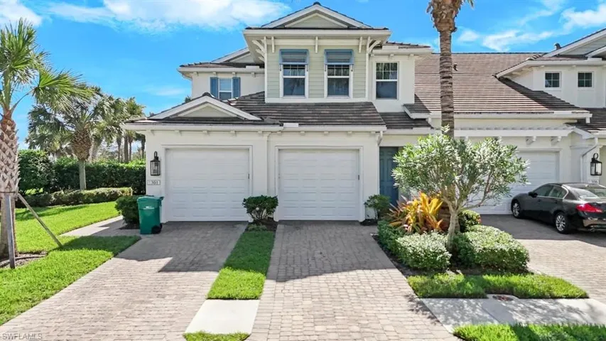 View of front of home with stucco siding, driveway, and a tiled roof