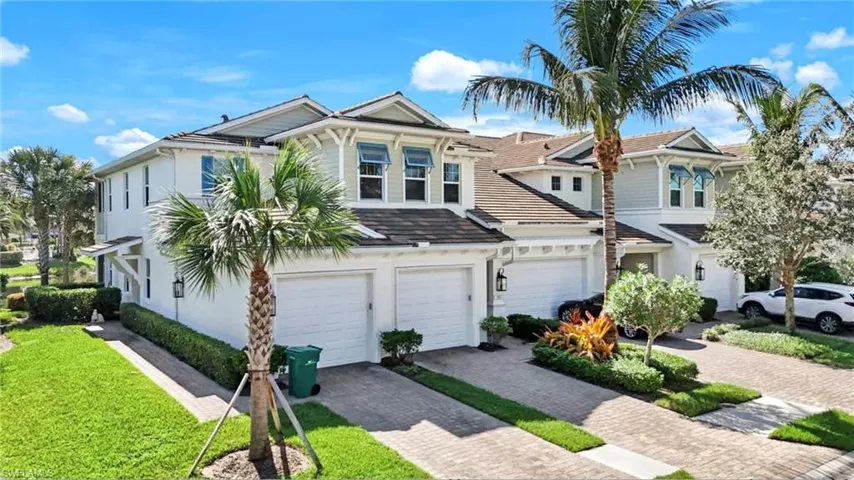 View of front of property with driveway, an attached garage, a front yard, and stucco siding