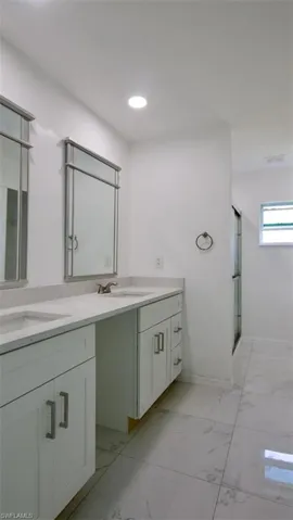 Double vanity with white cabinetry and light-toned countertops