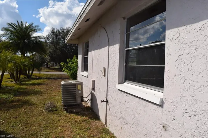 View of side of property featuring stucco siding and a yard