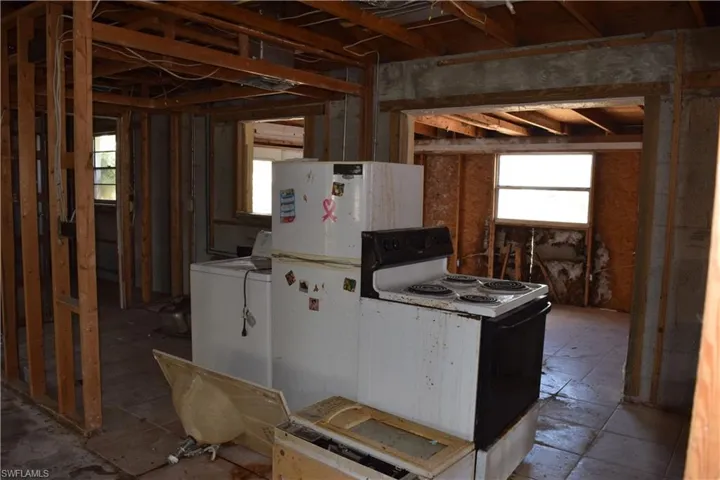 Kitchen with electric stove and freestanding refrigerator