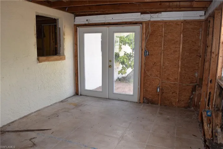 Doorway with a textured wall and french doors