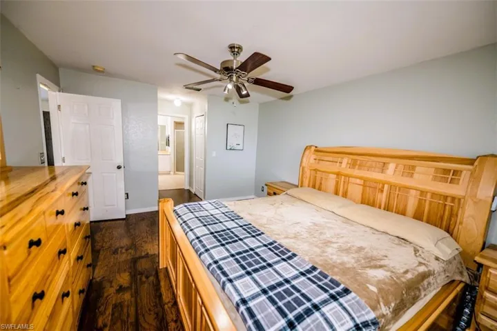 Bedroom featuring dark wood finished floors, a ceiling fan, connected bathroom, and a closet