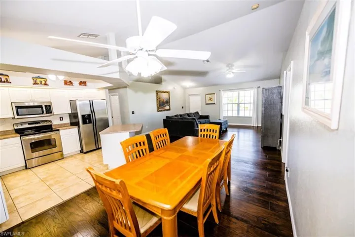 Dining room with lofted ceiling, light wood-style flooring, and ceiling fan