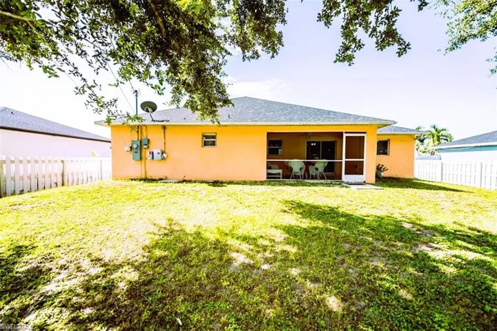 Rear view of property with a sunroom, a fenced backyard, stucco siding, and a ceiling fan
