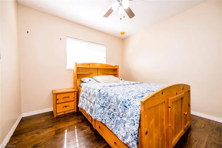 Bedroom with dark wood-type flooring and a ceiling fan