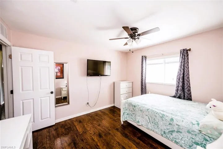 Bedroom with dark wood-style floors and a ceiling fan