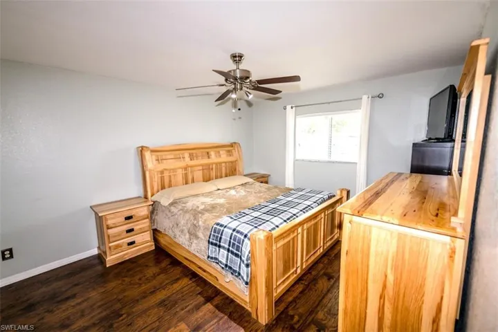 Bedroom with dark wood-style flooring and ceiling fan