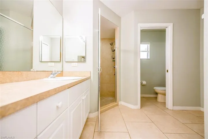 Bathroom with vanity, a stall shower, and tile patterned flooring